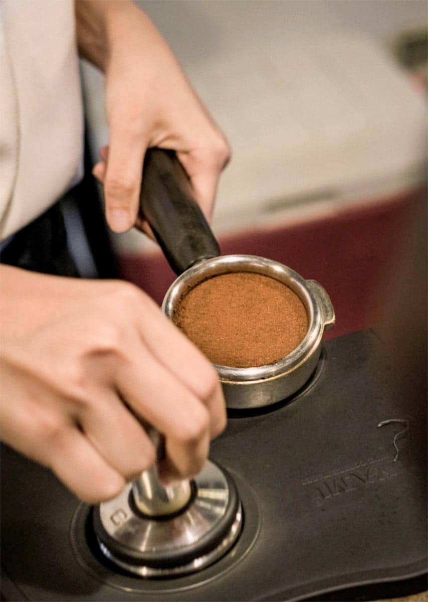tamping espresso on bench